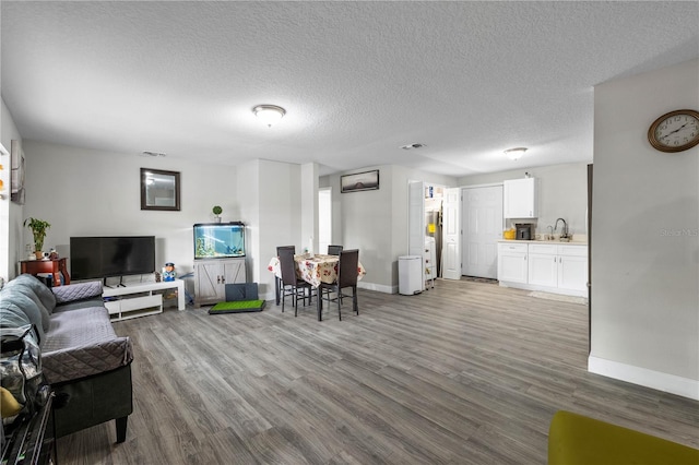 2804 Robinson Rd, Plant City, FL 33565 - living room featuring a textured ceiling, wood finished floors, baseboards, and visible vents