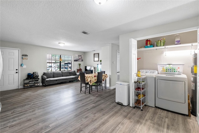 2804 Robinson Rd, Plant City, FL 33565 - clothes washing area featuring separate washer and dryer, a textured ceiling, visible vents, laundry area, and wood finished floors