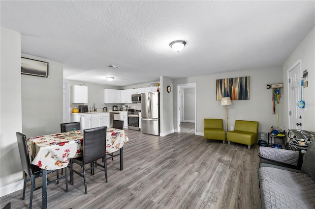 2804 Robinson Rd, Plant City, FL 33565 - dining area featuring a textured ceiling, wood finished floors, and baseboards