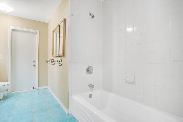 7938 Riffle Ln, Orlando, FL 32818 - bathroom with baseboards, toilet, tile patterned flooring, and bathtub / shower combination