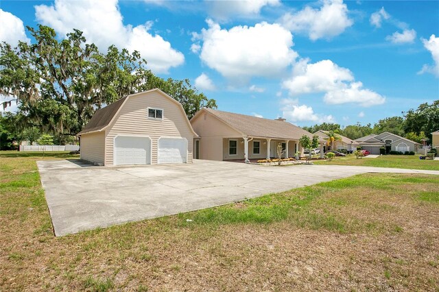 7938 Riffle Ln, Orlando, FL 32818 - view of front of house with a gambrel roof, a detached garage, an outbuilding, and a front yard