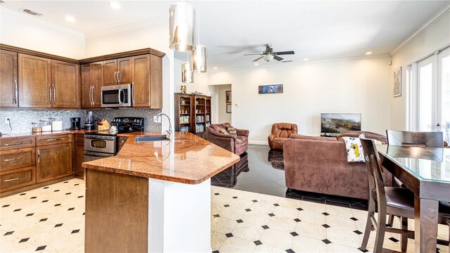 2734 Eagle Lake Dr, Orlando, FL 32837 - kitchen featuring stainless steel appliances, a peninsula, a sink, open floor plan, and ceiling fan