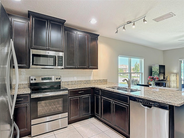 328 Vestrella Dr, Poinciana, FL 34759 - kitchen featuring visible vents, a sink, a peninsula, stainless steel appliances, and decorative backsplash