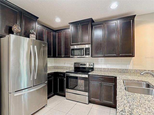 328 Vestrella Dr, Poinciana, FL 34759 - kitchen featuring tasteful backsplash, light tile patterned floors, a sink, stainless steel appliances, and light stone counters