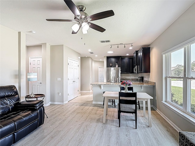 328 Vestrella Dr, Poinciana, FL 34759 - dining area featuring visible vents, a ceiling fan, light wood-style floors, and a textured ceiling
