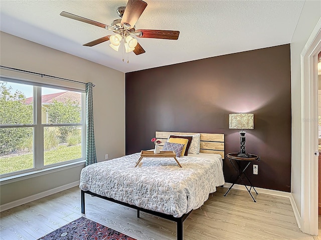 328 Vestrella Dr, Poinciana, FL 34759 - bedroom with light wood finished floors, baseboards, a textured ceiling, and ceiling fan