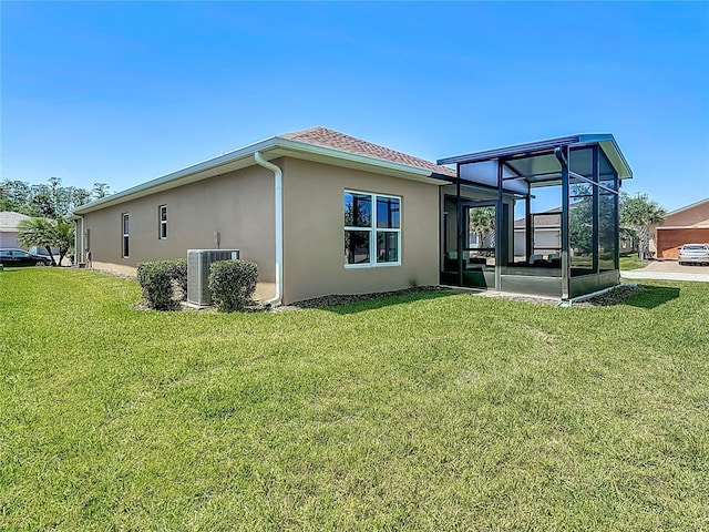 328 Vestrella Dr, Poinciana, FL 34759 - rear view of property featuring central air condition unit, stucco siding, a sunroom, and a lawn