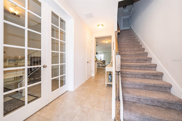 staircase featuring tile patterned flooring, french doors, and baseboards