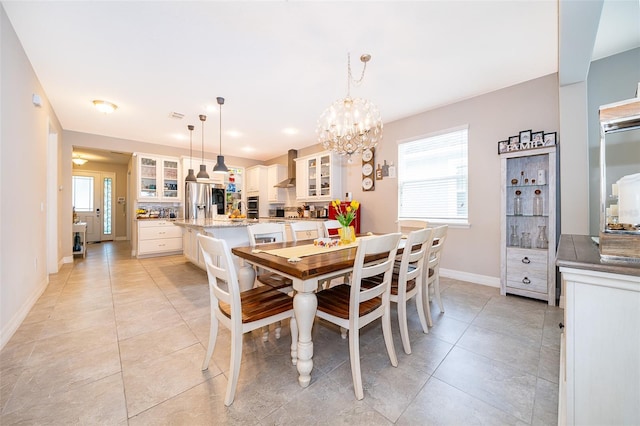 dining area featuring light tile patterned floors, baseboards, and a chandelier