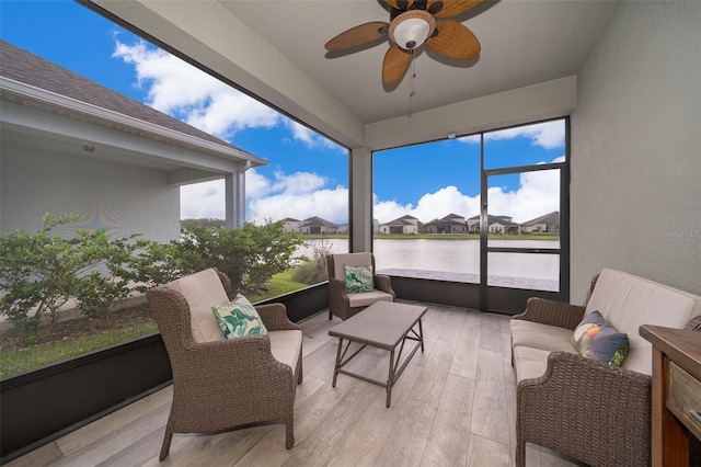 sunroom / solarium featuring a water view, plenty of natural light, ceiling fan, and an outdoor hangout area