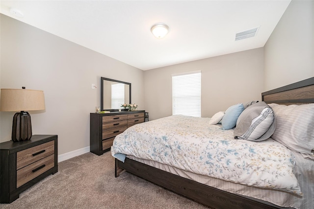 bedroom with visible vents, baseboards, and light carpet