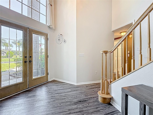 foyer featuring stairs, a towering ceiling, and wood finished floors