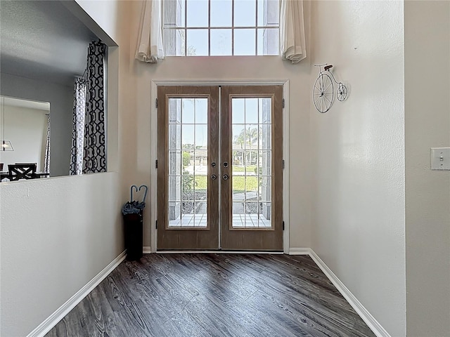 doorway featuring french doors, baseboards, and wood finished floors