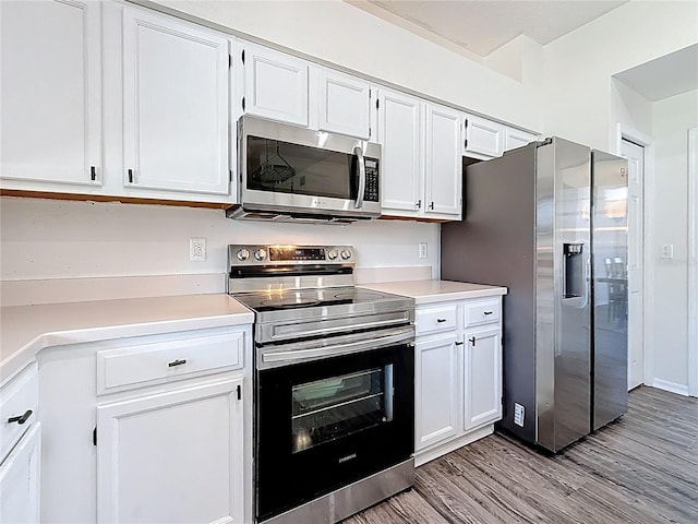 kitchen featuring stainless steel appliances, light wood finished floors, light countertops, and white cabinetry