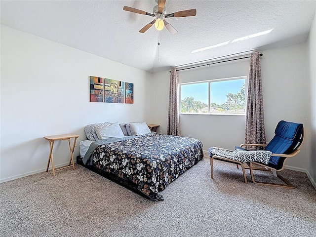 bedroom with ceiling fan, a textured ceiling, baseboards, and carpet floors