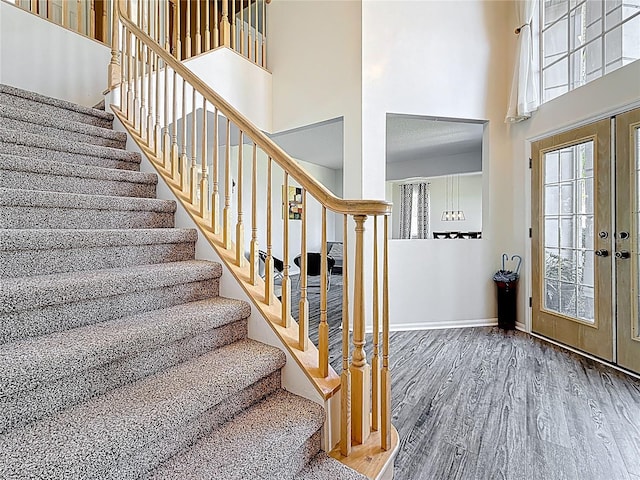 entrance foyer with baseboards, a high ceiling, wood finished floors, and stairs