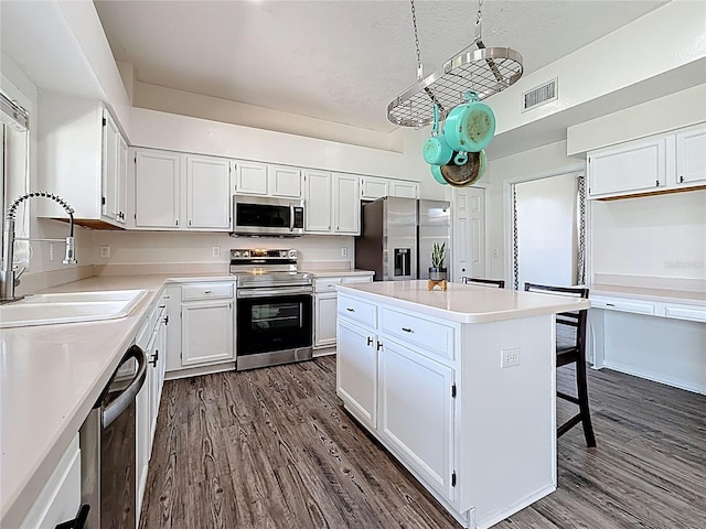 kitchen with a sink, visible vents, appliances with stainless steel finishes, and dark wood-style floors