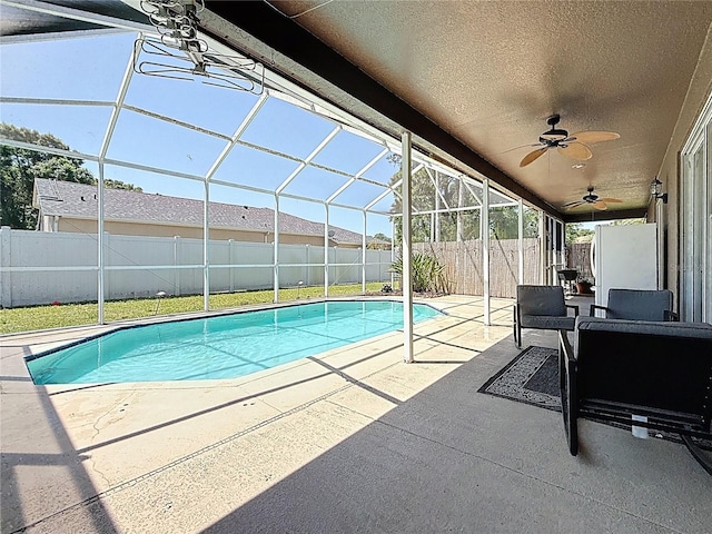 view of swimming pool with a fenced in pool, a ceiling fan, a patio area, a fenced backyard, and a lanai