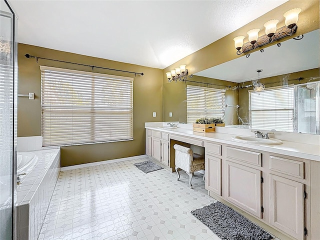 bathroom with a sink, baseboards, double vanity, and a garden tub