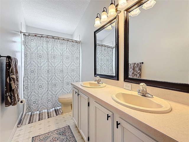 full bath featuring toilet, a textured ceiling, double vanity, and a sink