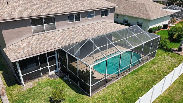 back of house with a shingled roof, a patio area, glass enclosure, stucco siding, and a fenced in pool