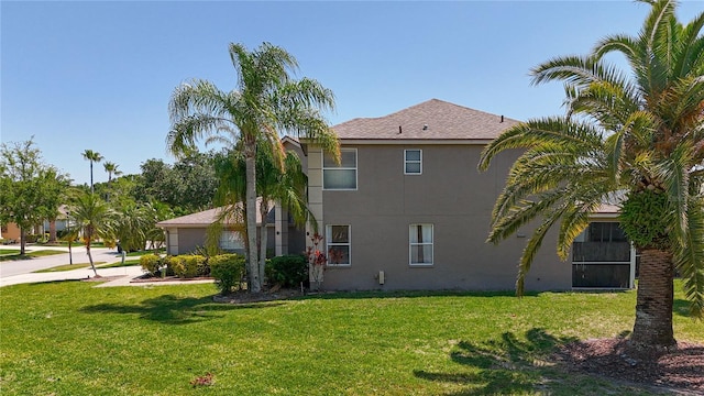 view of side of property featuring a yard and stucco siding