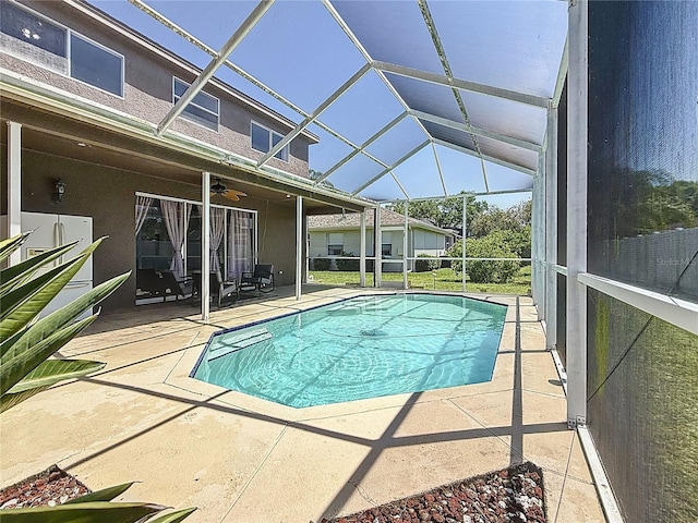 outdoor pool featuring a patio area, a lanai, and a ceiling fan