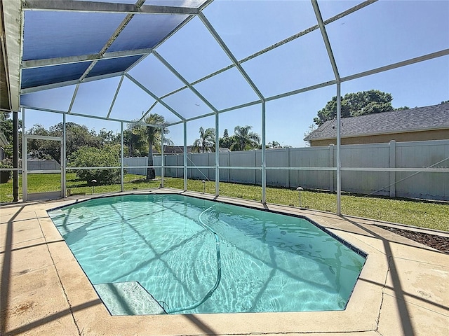 view of pool featuring a patio area, a fenced backyard, glass enclosure, and a lawn