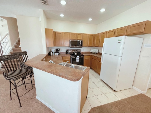 141 Summer Place Loop, Clermont, FL 34714 - kitchen with stainless steel appliances, a peninsula, recessed lighting, a breakfast bar area, and light tile patterned floors