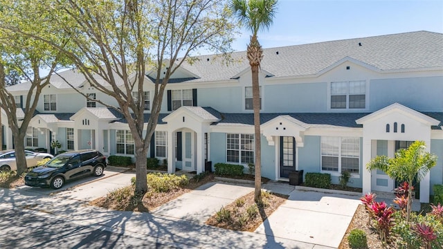 multi unit property featuring stucco siding and roof with shingles