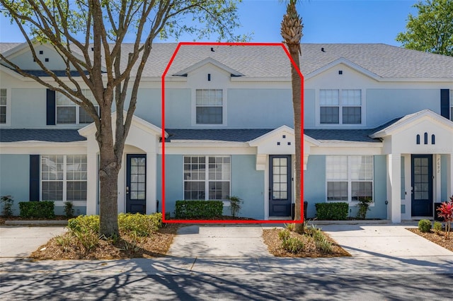 multi unit property featuring stucco siding and a shingled roof