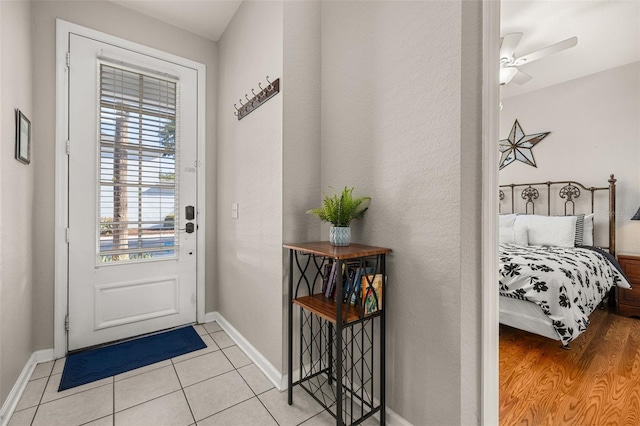 entryway featuring ceiling fan, tile patterned floors, and baseboards
