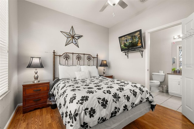 bedroom featuring light wood-style flooring, ceiling fan, and ensuite bathroom