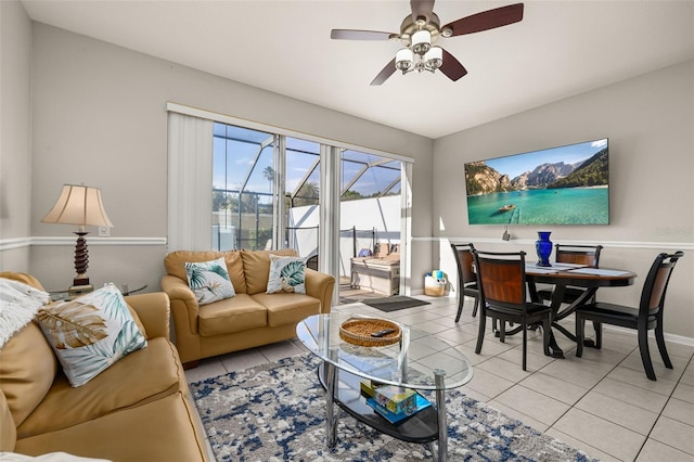living room featuring light tile patterned floors, ceiling fan, and baseboards