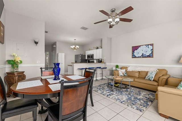dining room with light tile patterned flooring, visible vents, and ceiling fan with notable chandelier