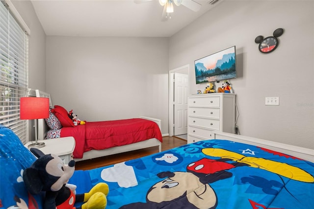 bedroom featuring baseboards, wood finished floors, and a ceiling fan