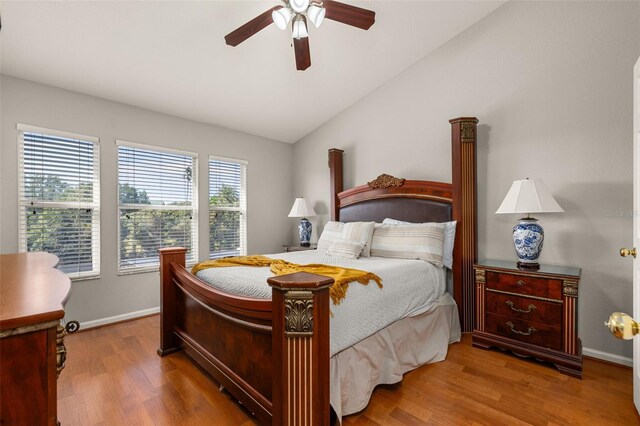 bedroom featuring baseboards, wood finished floors, ceiling fan, and vaulted ceiling