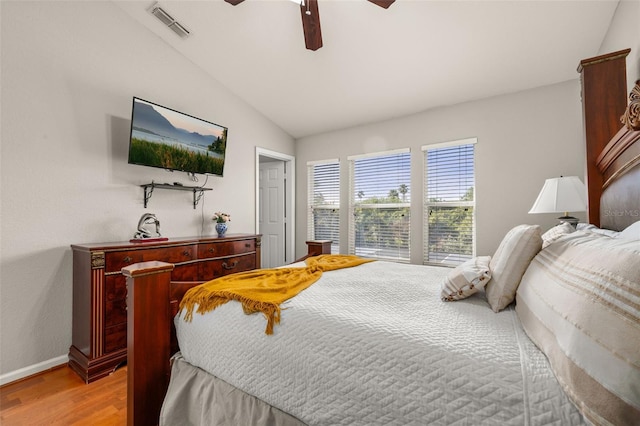 bedroom with lofted ceiling, visible vents, baseboards, light wood-type flooring, and a ceiling fan