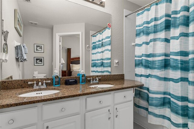 full bathroom with double vanity, visible vents, a shower with curtain, and a sink