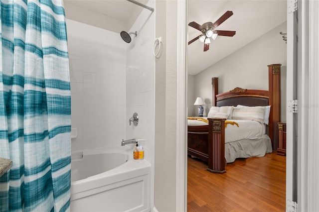 bathroom featuring wood finished floors, a ceiling fan, shower / tub combo with curtain, lofted ceiling, and ensuite bathroom