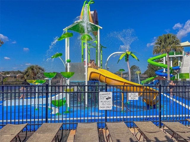 view of pool with a pool, playground community, and fence
