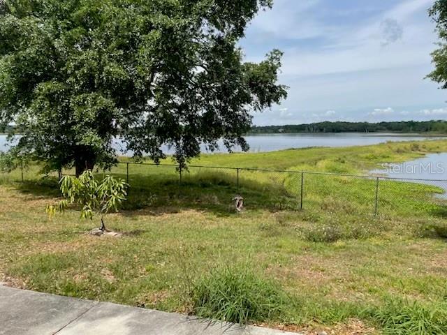 view of yard with a water view and fence
