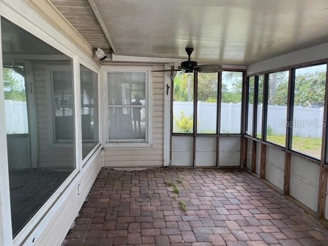 unfurnished sunroom with a ceiling fan