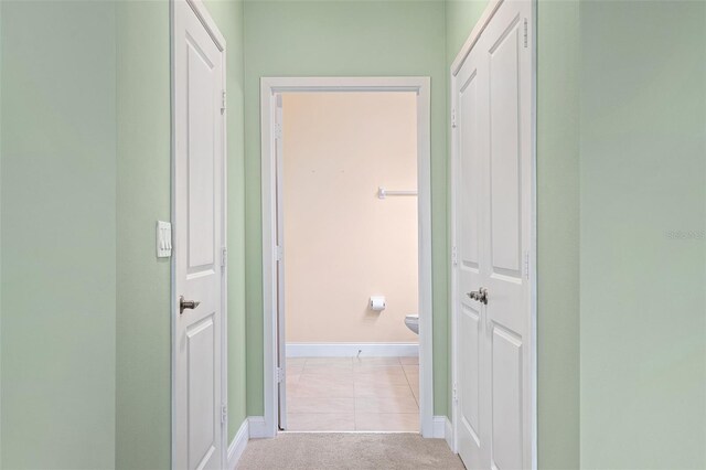 7505 Laureate Blvd Unit 2208, Orlando, FL 32827 - corridor featuring light tile patterned floors, light colored carpet, and baseboards