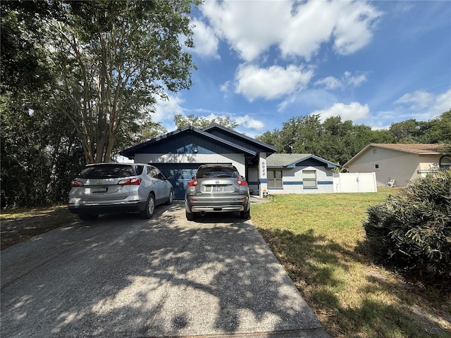 6922 Doehring Dr, Lakeland, FL 33810 - view of front of home with a garage, fence, driveway, and a front lawn