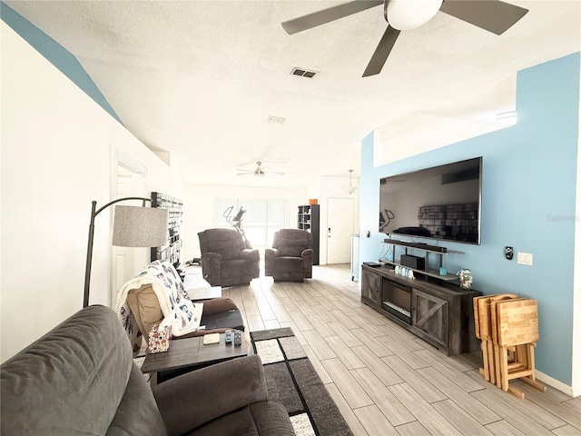 6922 Doehring Dr, Lakeland, FL 33810 - living room featuring wood finish floors, a textured ceiling, a ceiling fan, baseboards, and visible vents