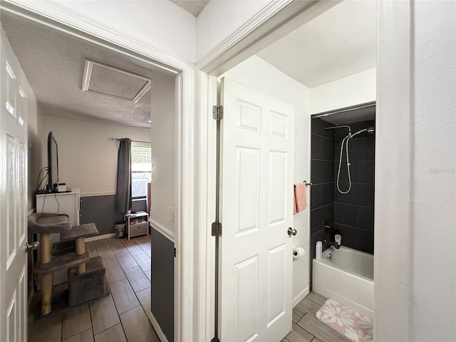 6922 Doehring Dr, Lakeland, FL 33810 - bathroom with bathing tub / shower combination, baseboards, wood finish floors, and a textured ceiling