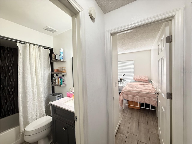 6922 Doehring Dr, Lakeland, FL 33810 - ensuite bathroom featuring ensuite bathroom, a textured ceiling, wood finish floors, and toilet