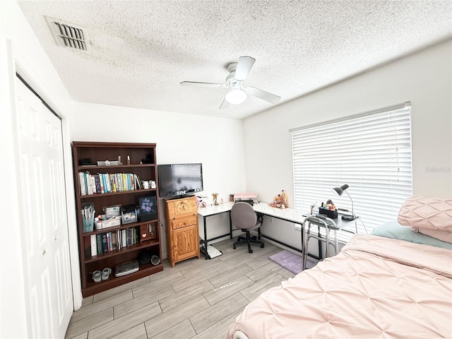 6922 Doehring Dr, Lakeland, FL 33810 - bedroom featuring a ceiling fan, a textured ceiling, visible vents, wood finish floors, and a closet