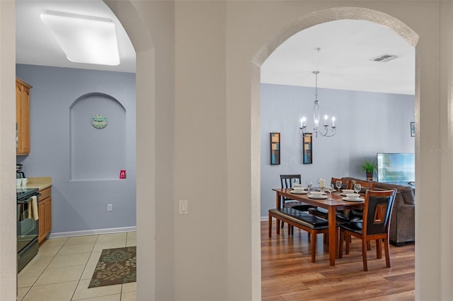 4862 Cayview Ave Unit 407, Orlando, FL 32819 - dining area with arched walkways, an inviting chandelier, baseboards, and visible vents